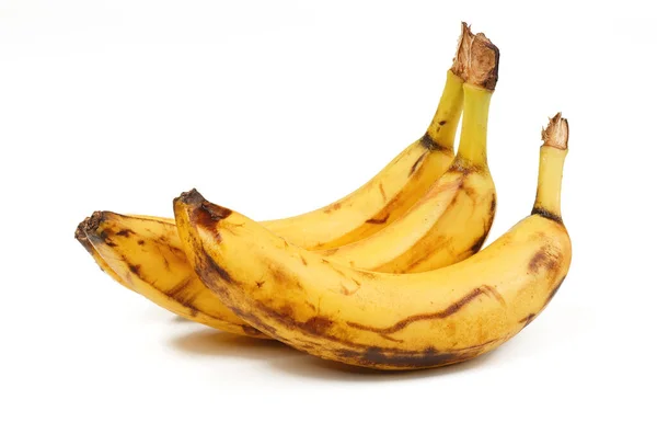 Olgun sarı muzlu meyveler, beyaz arka planda koyu benekli olgun muzlar..