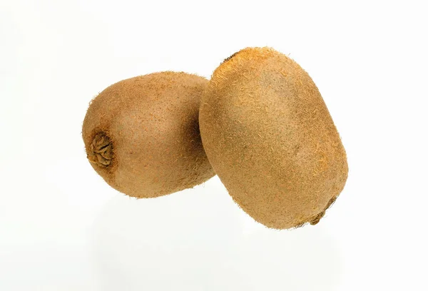 Beyaz arka planda tam iki kivi meyvesi