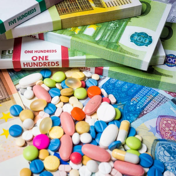 Geld und Pillen. Pillen in verschiedenen Farben auf Geld. Medizin-Co — Stockfoto