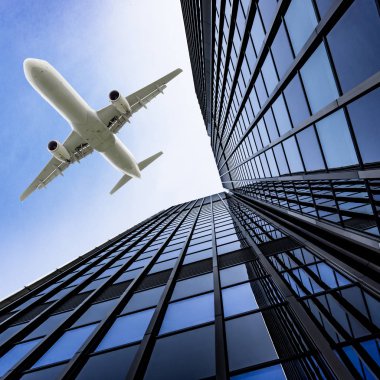 Mavi gökyüzü uçan bir uçak ile gökdelenler