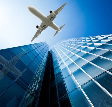 Mavi gökyüzü uçan bir uçak ile gökdelenler