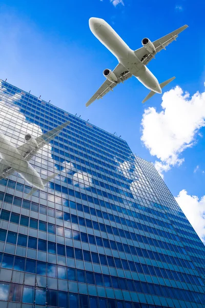 Skyscrapers with a flying airplane against blue sky — Stock Photo, Image