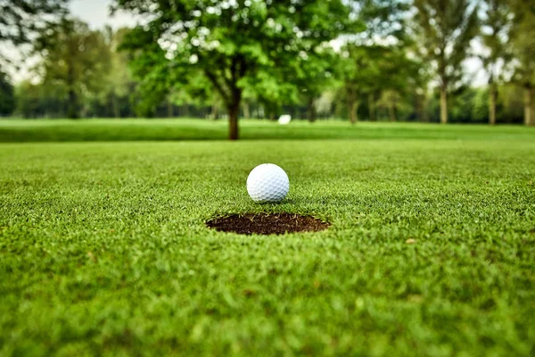 Golfball auf dem Grün. Golfball auf Becherlippe — Stockfoto