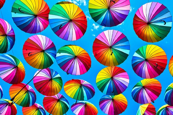 Regenboog paraplu op de hemelachtergrond. Veel kleurrijke paraplu's. UMB — Stockfoto