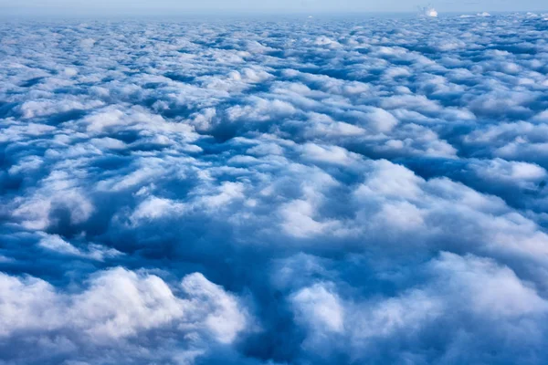 Nubes y cielo azul visto desde el avión — Foto de Stock