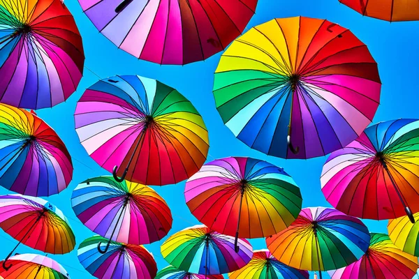 Rainbow parasol na tle nieba. Wiele kolorowych parasoli. UMB — Zdjęcie stockowe