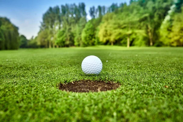 Golf ball on the green. golf ball on lip of cup Stock Photo