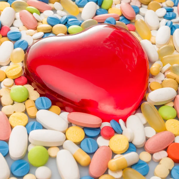 Corazón con pastillas. pastillas de colores. antecedentes médicos — Foto de Stock