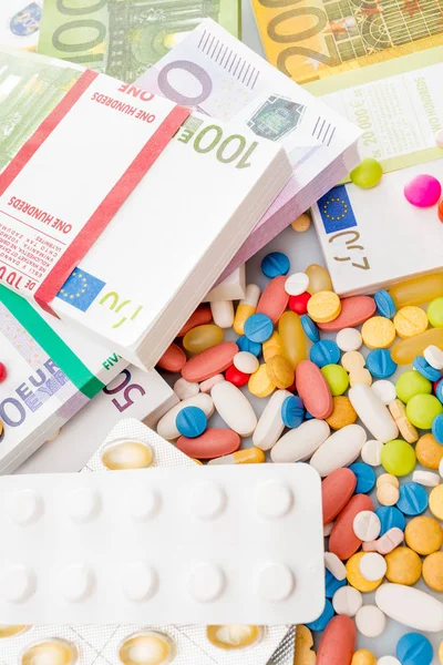 Гроші і таблетки. Таблетки різних кольорів на гроші. медицина спільно — стокове фото