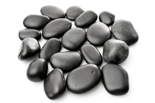 Piedras de masaje en blanco. Piedras negras aisladas — Foto de Stock