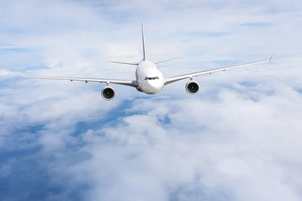 O avião voa num céu azul nublado. Avião no céu — Fotografia de Stock