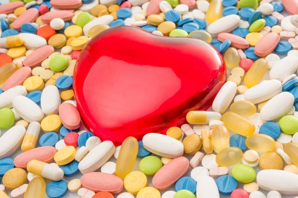 Corazón con pastillas. pastillas de colores. antecedentes médicos —  Fotos de Stock