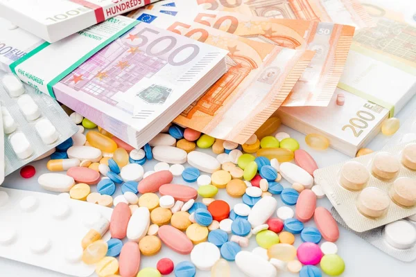 Pénz és a tabletták. Pirula a különböző színek a pénzt. gyógyszer-co — Stock Fotó