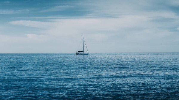 Sailing boat on Blue sea with heavy storm clouds. Sailing yacht 