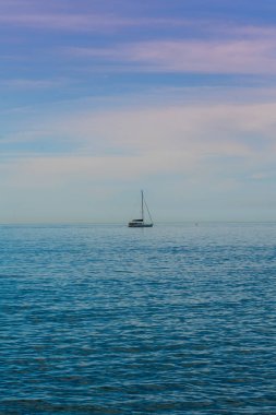 Ağır fırtına bulutları ile mavi denizde yelkenli tekne. Yelkenli yat 