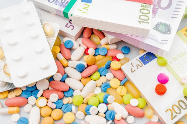 Χρήματα και χάπια. Χάπια από διαφορετικά χρώματα για τα χρήματα. ιατρική co — Φωτογραφία Αρχείου