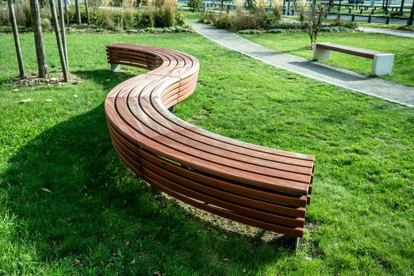 Egy modern pad egy városi parkban egy napsütéses napon. — Stock Fotó