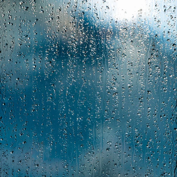 Starkregen tropft auf blaues Fenster — Stockfoto