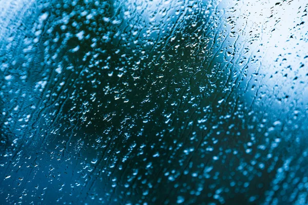 Chuva pesada cai na janela azul — Fotografia de Stock