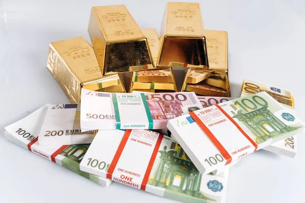 Biliões de ouro em notas de euro fundo close-up. Barras de ouro jazem nas notas de euro — Fotografia de Stock