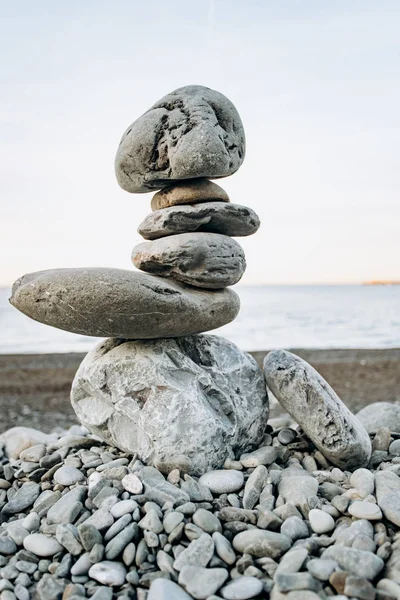 La figura de piedras de pie uno sobre el otro, en la playa contra el mar. — Foto de Stock