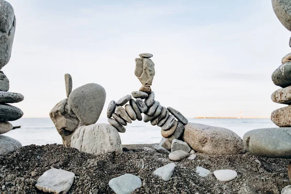 海の近くのビーチでの石の数字。海の背景と石像. — ストック写真