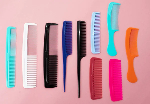 Various colored brushs and combs for hair on pink background. co — Stock Photo, Image