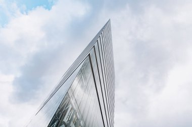 Bulutlu gökdelenlere karşı dramatik bir manzara. Aşağıdan gökdelenin görüntüsü
