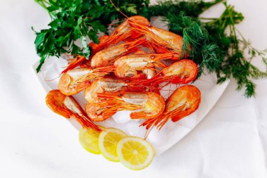 Limon ve dereotlu bir tabakta karides. Beyaz arkaplan