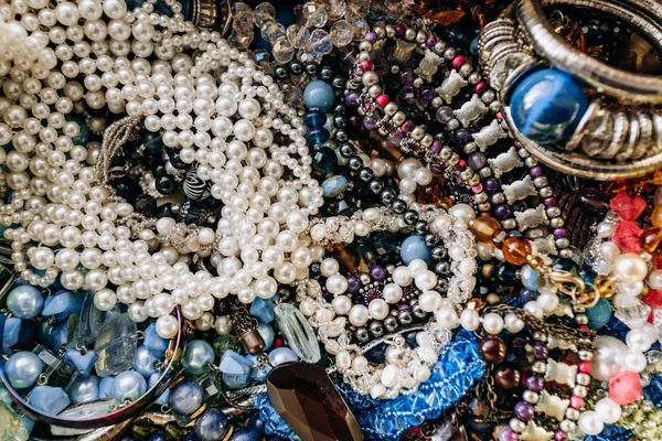 Perlen und Halsketten aus farbigen Halbedelsteinen. Hintergrund aus einer Vielzahl von schönen Schmuckstücken, bunten türkisfarbenen Steinen, Bernstein, Katzenauge, Perlen. — Stockfoto