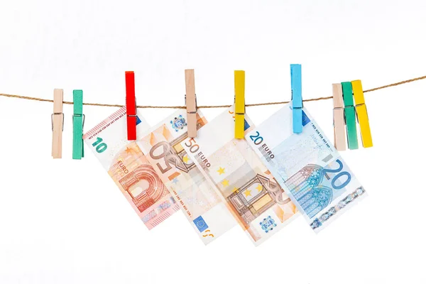 Eurobankovky jsou připevněny kolíky různých barev na provaze na bílém pozadí — Stock fotografie