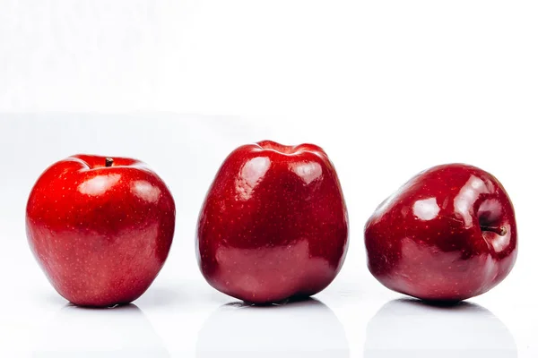 Alcune mele rosse fresche su uno sfondo bianco con un bel riflesso — Foto Stock