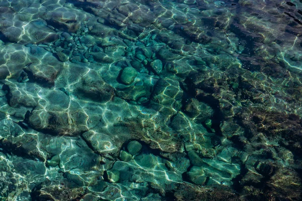 Pozadí tyrkysové vody v moři. Tyrkysová textura vody se zvýrazněním. — Stock fotografie