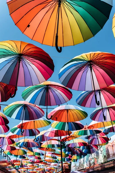 푸른 하늘 배경에 무지개 빛깔의 우산 — 스톡 사진
