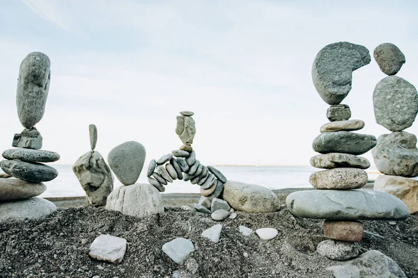 Végtelenül egymásra rakott kövek és kőfigurák a tenger mellett. — Stock Fotó