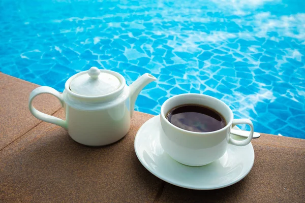 Cup on the table near the pool . White ceramic coffee cup — Stock Photo, Image