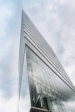 Bulutlu gökdelenlere karşı dramatik bir manzara. Aşağıdan gökdelenin görüntüsü