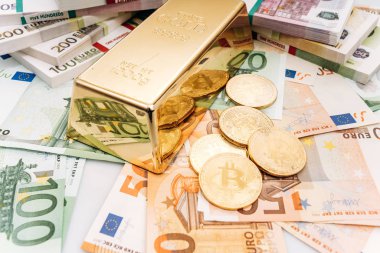 Avro banknotları ve altın külçeleriyle Bitcoin Btc Gold sikkeleri. Bitcoin ve altın Euro banknotlarında yatıyor