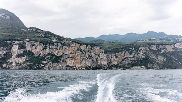 Ślad łodzi na morzu. Morze z górami w tle — Zdjęcie stockowe