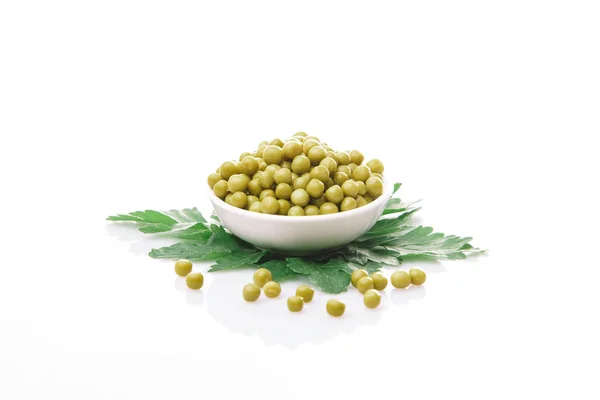 Peas in a white plate on a white background — Stock Photo, Image