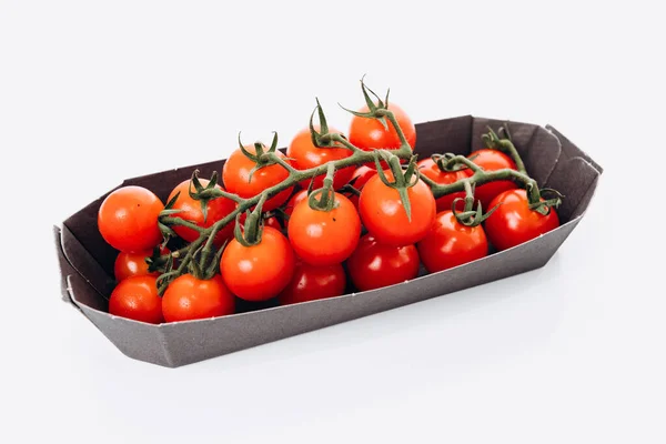 Punaisia tomaatteja muovipakkauksessa. Eristetty, valkoinen tausta. Valkoinen tausta ja pohdinta . — kuvapankkivalokuva