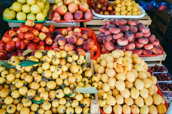 Fruta fresca en el mercado. Albaricoques, melocotones en el mercado . — Foto de Stock