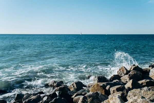 Kamienie na plaży. Fale morza biją o skały na brzegu. Piękny widok na morze. — Zdjęcie stockowe