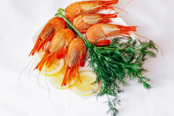 Camarones en un plato con limón y eneldo. Fondo blanco — Foto de Stock