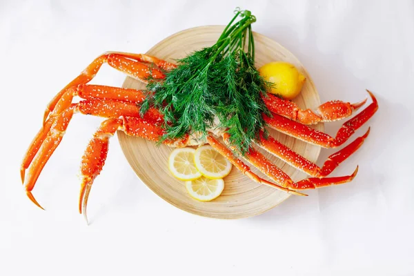 Crabe, citron et aneth sur une assiette sur fond blanc. — Photo