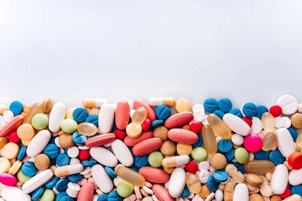 Olika läkemedel medicin piller, tablett. Piller bakgrund. Heap av olika diverse tabletter medicin och piller olika färger på vit bakgrund. Sjukvård. Ovanifrån — Stockfoto