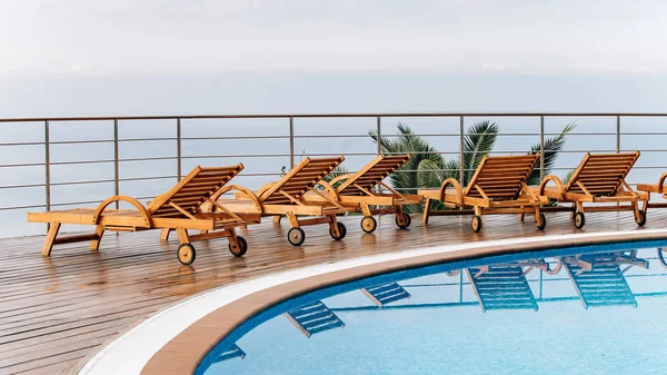 Houten ligstoelen in het hotel met prachtig uitzicht op de oceaan of de zee — Stockfoto