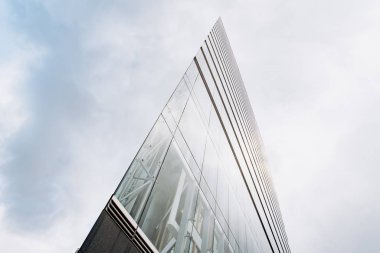 Bulutlu gökdelenlere karşı dramatik bir manzara. Aşağıdan gökdelenin görüntüsü