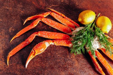 Kırmızı arka planda yengeç, bitki ve limon kompozisyonu