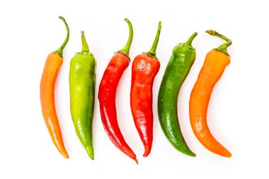 Kırmızı, yeşil biberler beyaz arka planda izole edilmiş.